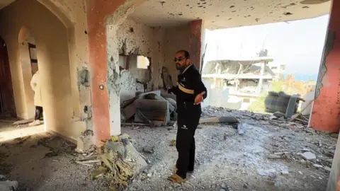 Prof Abu Shiha arrives at what remains of his house in Nuseirat.
