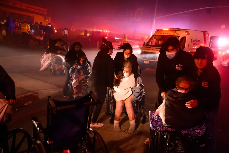 Thousands flee as winds drive wildfires into Los Angeles