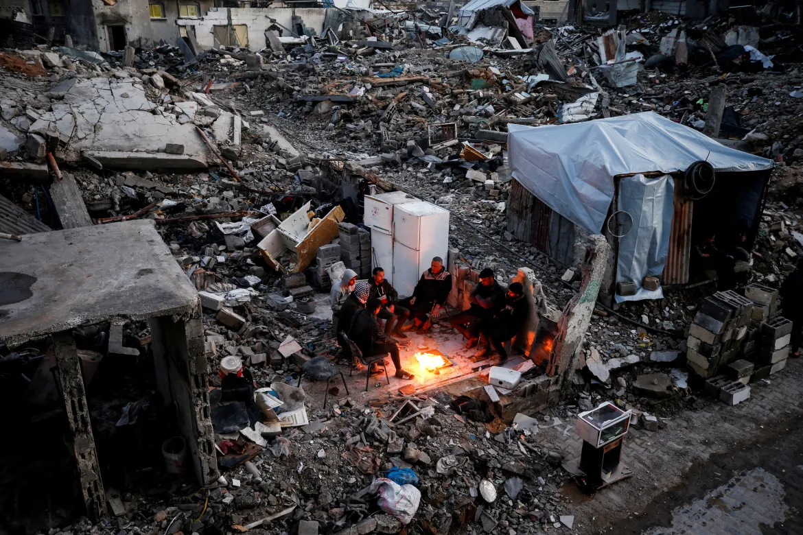 Displaced Palestinians wait for aid amid the rubble of Gaza’s destruction