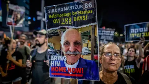 Getty Images An Israeli woman holds a placard showing Shlomo Mantzur